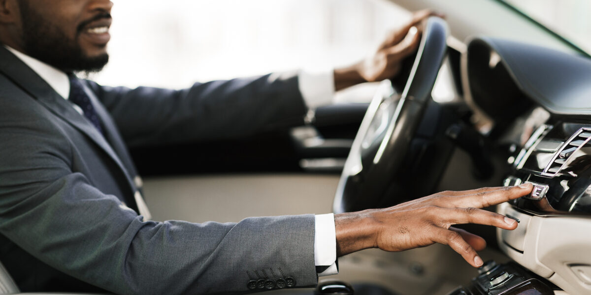 Test Drive. Relaxed Black Man Driving Car Listening To Music On Radio Sitting In New Automobile. Shallow Depth, Selective Focus